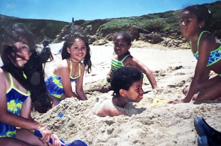 Lower graders at the beach, boy is in the sand.